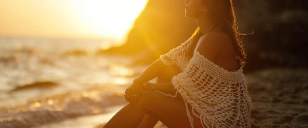 Beautiful Woman Relaxing On Sandy Beach At Sunset.